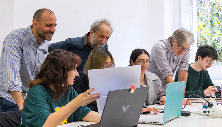 Docenti che guardano e valutano dei lavori.